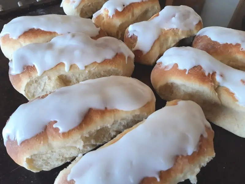 Bread rolls with white icing on top of each roll