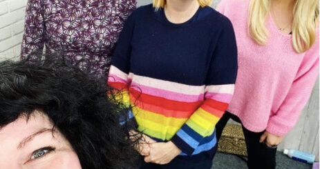 Four women are smiling at the camera in a selfie.