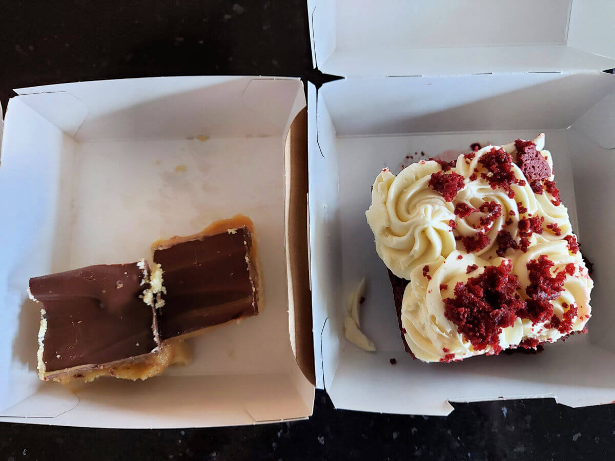Two cardboard boxes containing two different types of cake.