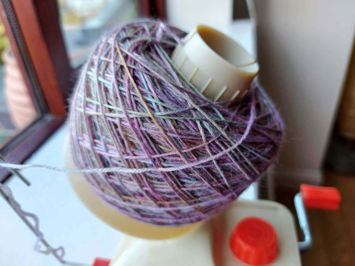 A large yarn cake is on the winder and all the yarn is used up.