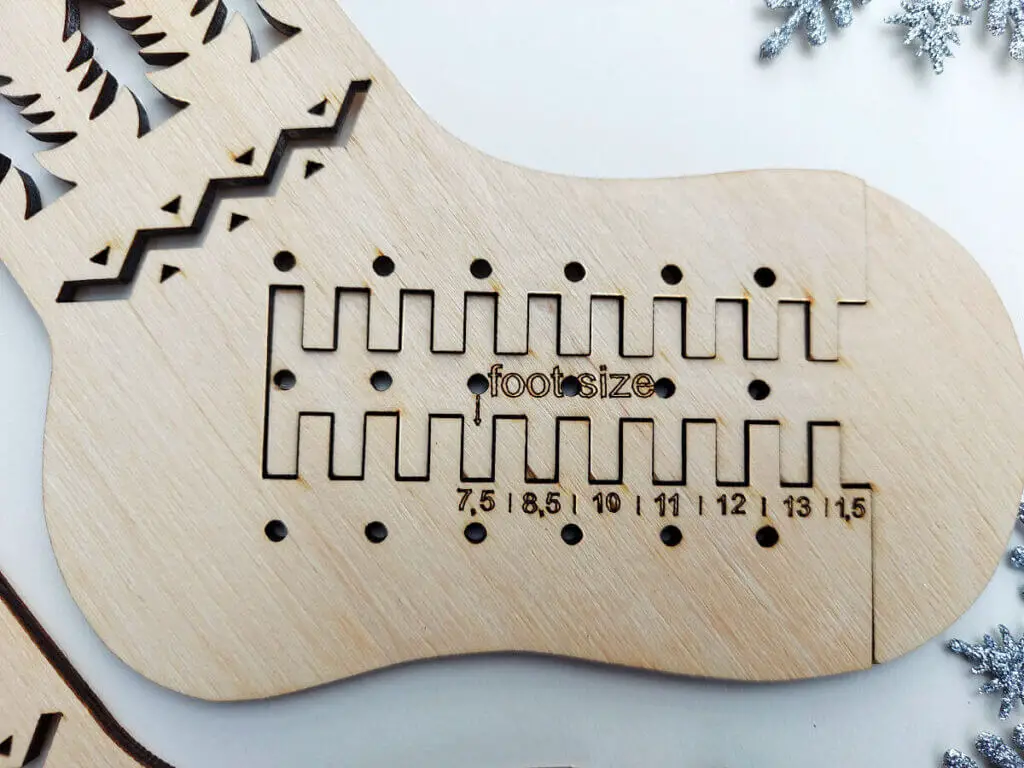 A close up view of the wooden sock blocker showing the foot sizes.