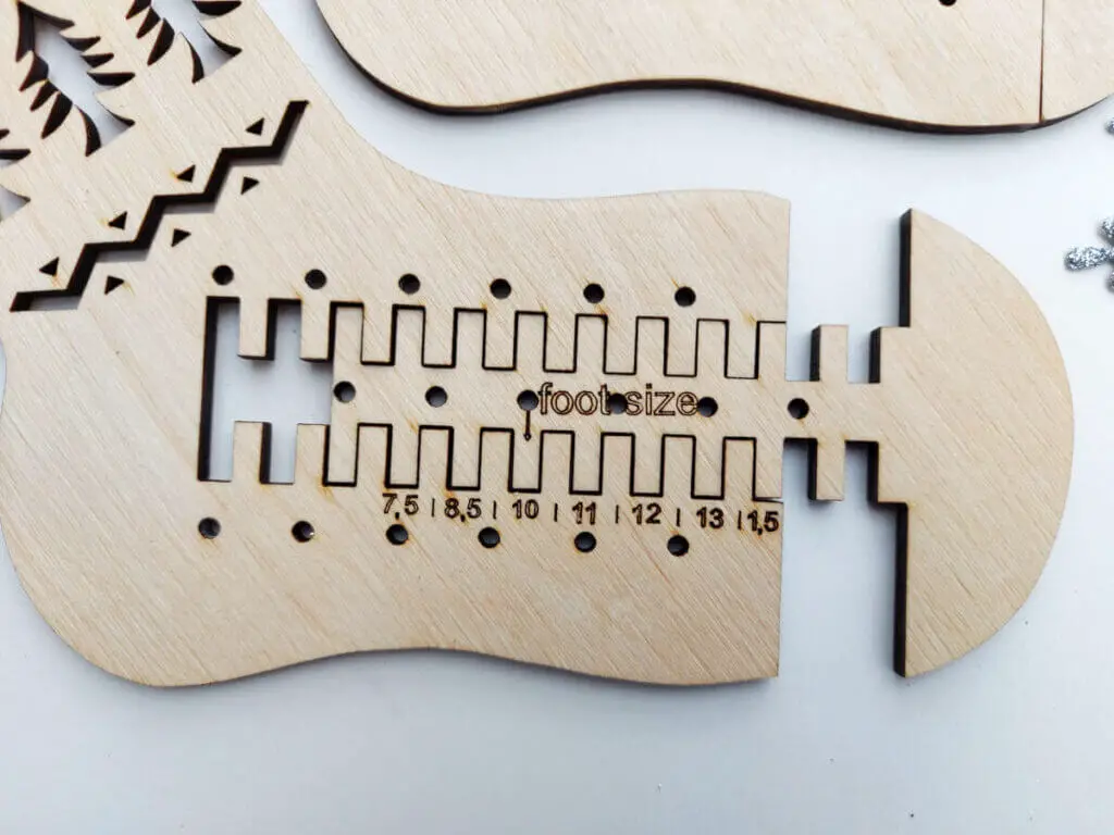 A close up of the foot of a wooden sock blocker showing the foot section extended along wooden teeth