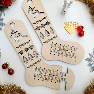A flatlay of adjustable wooden sock blockers surrounded by Christmas stars, red glass baubles, gold tinsel and a tiny ceramic reindeer.