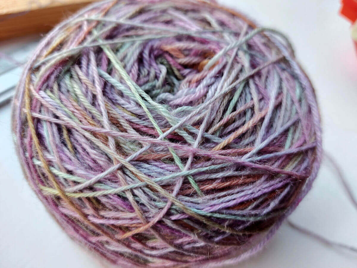 A photo of the pastel coloured yarn cake from above. Some of the yarn looks thinner as it has been pulled tighter across the cake.
