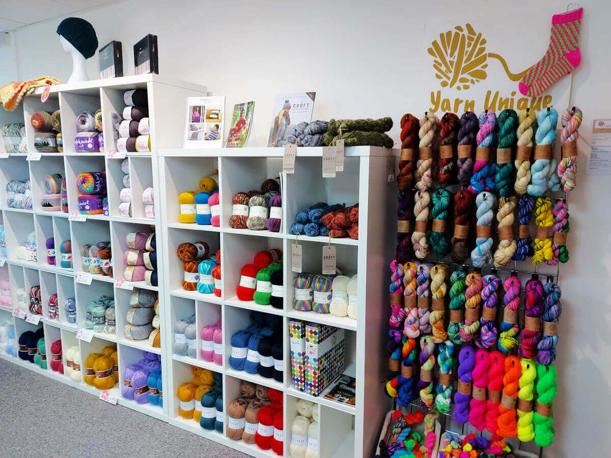 A view of the yarn shelves from the opposite direction. This time, you can see the rack of brightly coloured hand-dyed yarn.