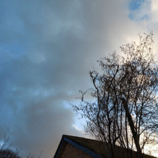 An ominous-looking sky of dark clouds above a roof top