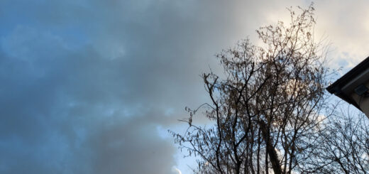 An ominous-looking sky of dark clouds above a roof top