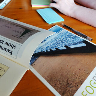 Paper booklets of geography revision notes lie on a wooden table.