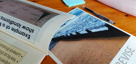 Paper booklets of geography revision notes lie on a wooden table.