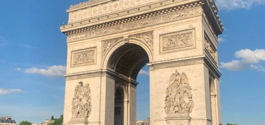 A large square moment with an arch in the middle against a blue sky