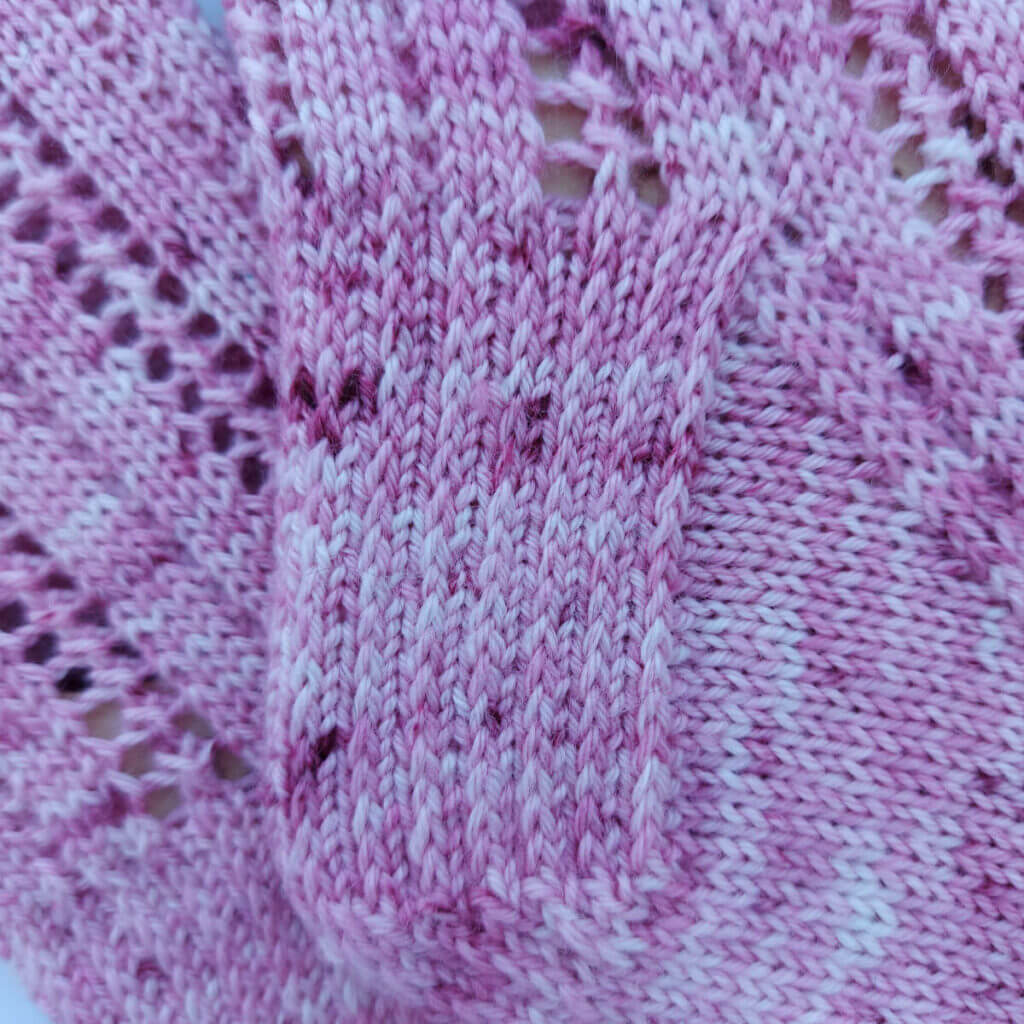 Close up of the heel flap of a pink knitted sock