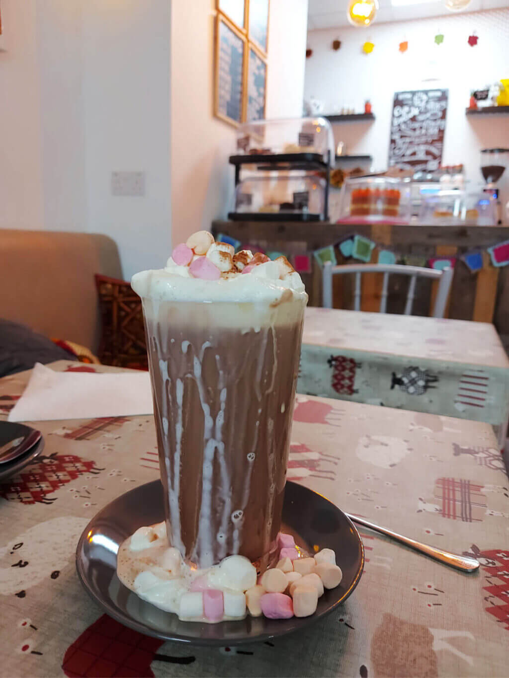A tall glass of hot chocolate on a cafe table