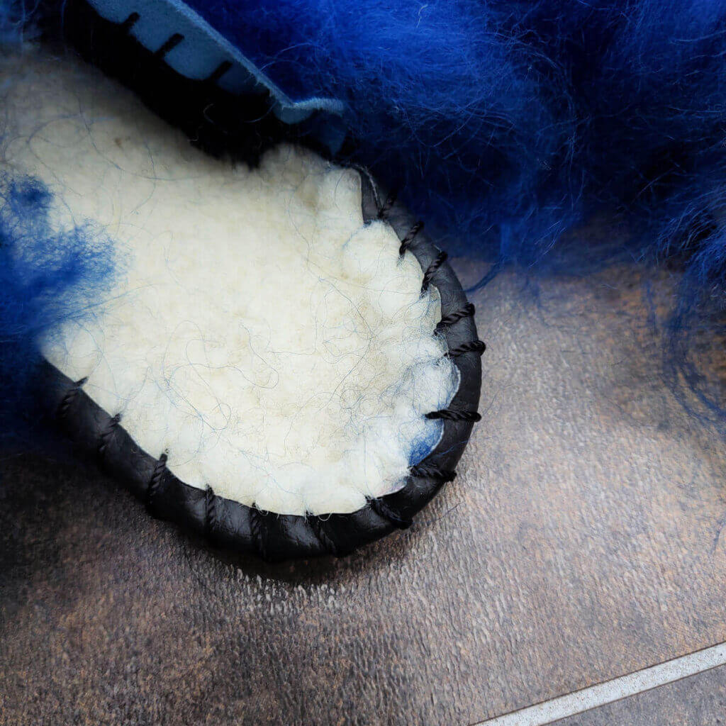 A close up of the inside of the Sheepers mule slipper showing the furry inner and the band sewn around the edge