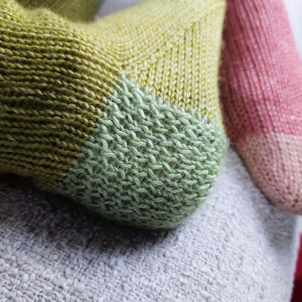 A close up of a green sock heel in Eye of Partridge stitch