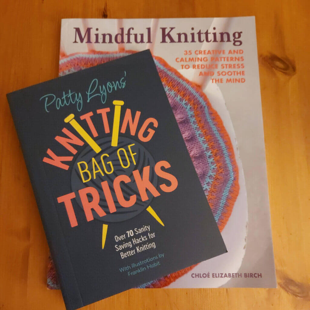 Two books on a wooden table. One is called Mindful Knitting and the other is called Patty Lyons' Knitting Bag of Tricks