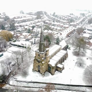 An aerial view of St Oswald's Church and Winwick village in the snow, credit www.snapshotstudios.co.uk