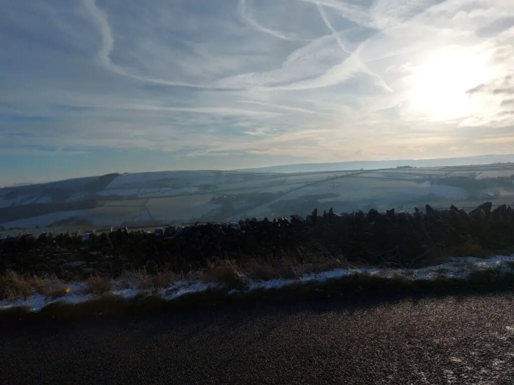 Vapour trails in the sky, and a view across the moors to the hills beyond