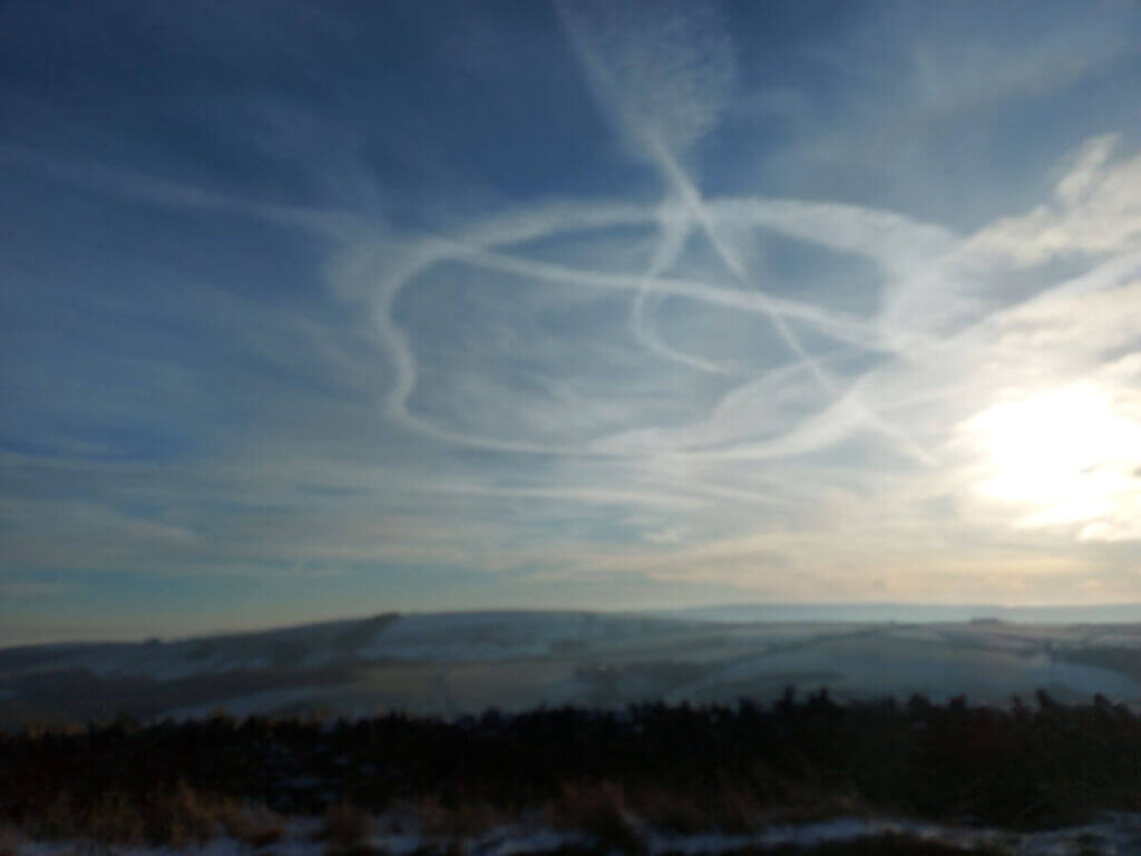 Vapour trails in the sky, and a view across the moors to the hills beyond