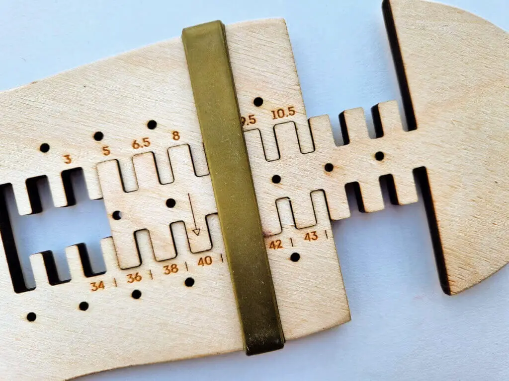 A gold coloured plastic band secures the two parts of an adjustable sock blocker together