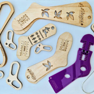 A selection of sock blockers made of wood, acrylic and wire are displayed on a white background