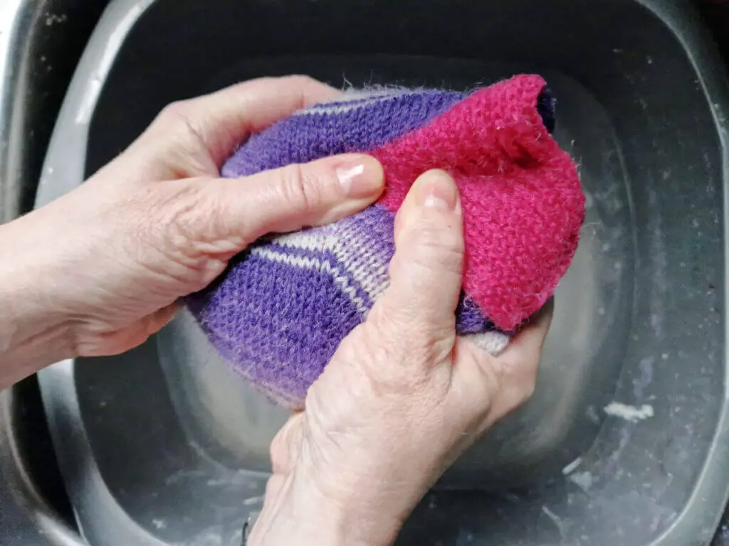 Squeezing the water out of hand knitted socks 