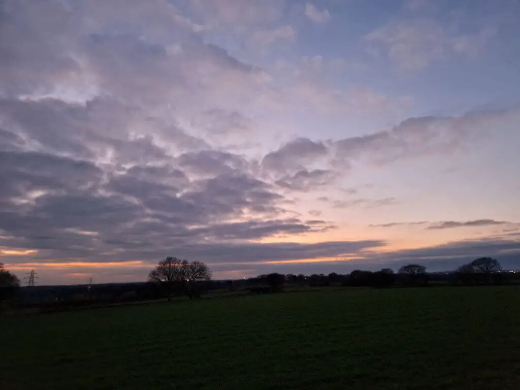 A pink sunset sky against grey clouds