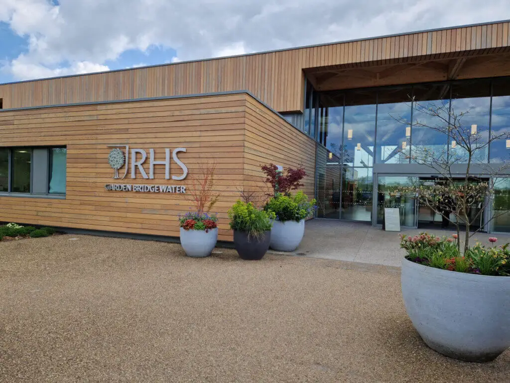 RHS Bridgewater garden front entrance. It is built in cedar wood and glass, with large planters outside the door