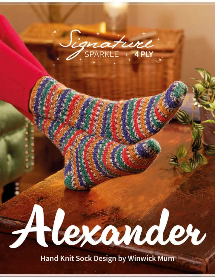 A pair of feet resting on a wooden coffee table, wearing hand knitted socks in stripes of blue, green, red and gold