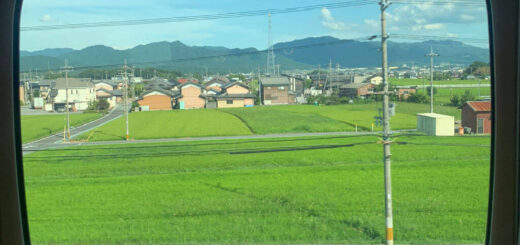 A view of Kyoto countryside through a round train window