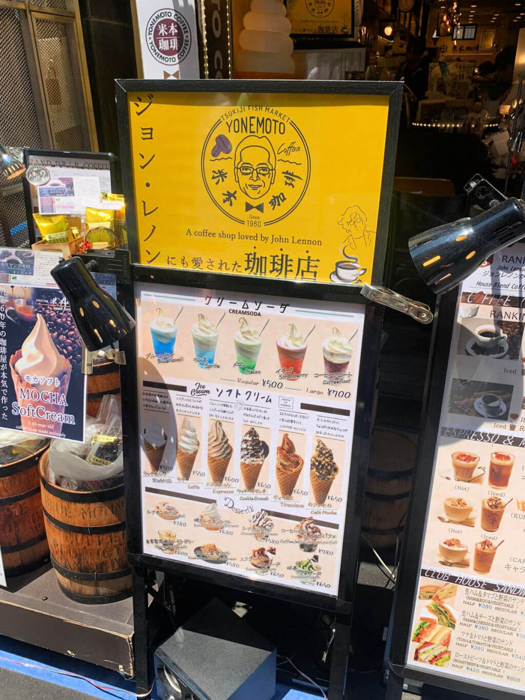 A large free-standing menu outside a cafe. The words on the menu say that John Lennon loved to visit