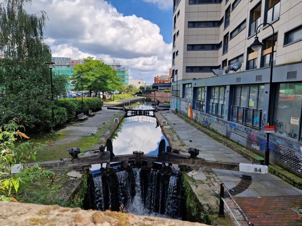 Canal locks in a city. There are tall buildings to one side.