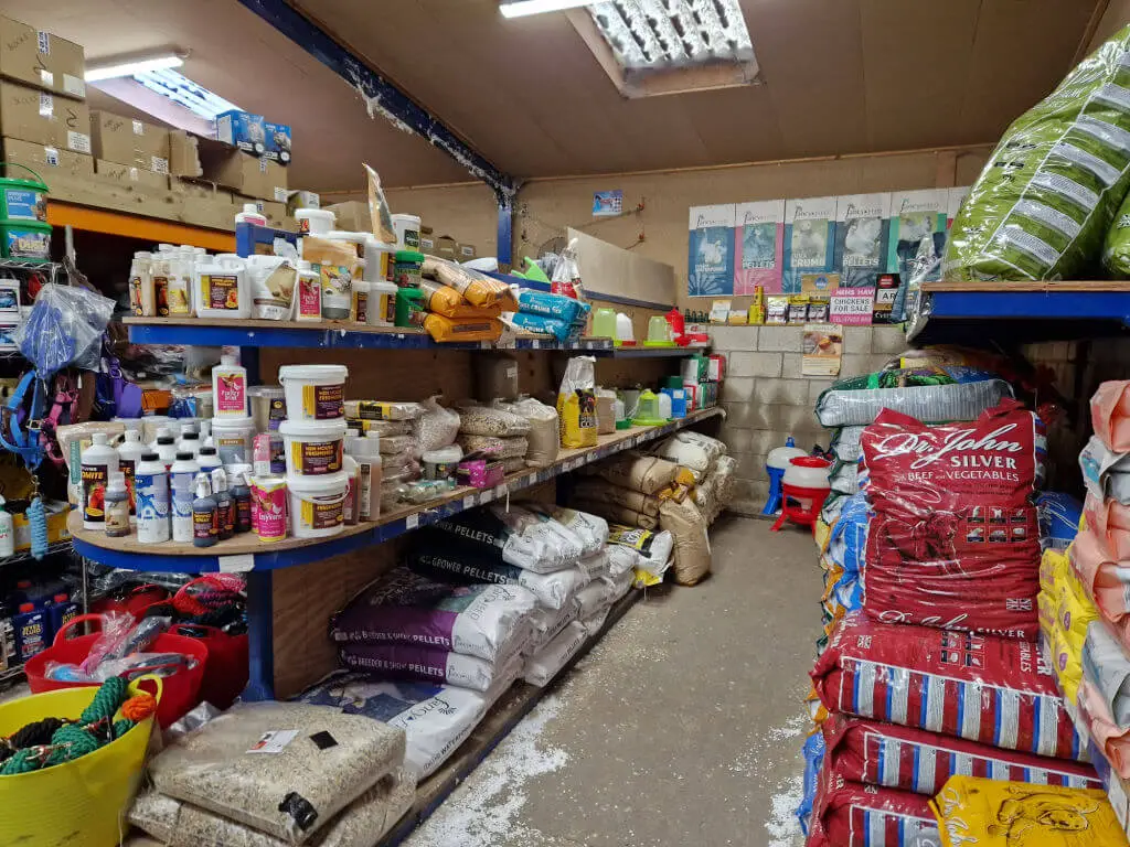 Shelves in a feed store full of bags of food for various livestock