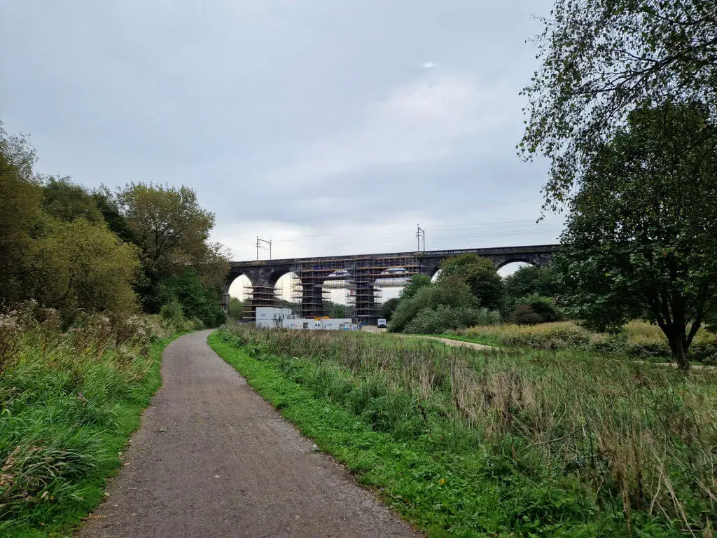 An arched railway viaduct from a closer distance.  There is scaffolding on the arches