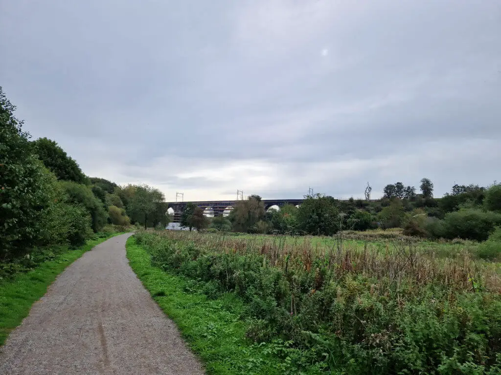 An arched railway viaduct from a distance.  There is scaffolding on the arches