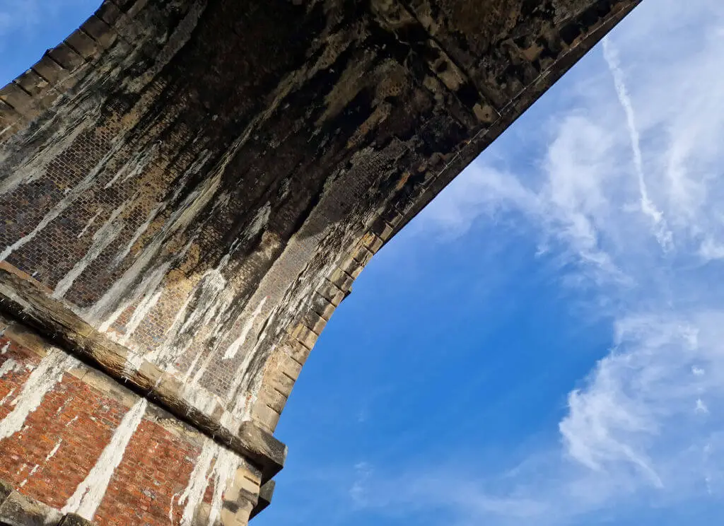 Blue sky on either side of a brick railway arch