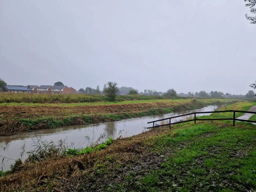 A fast-flowing brook between two banks on a grey day