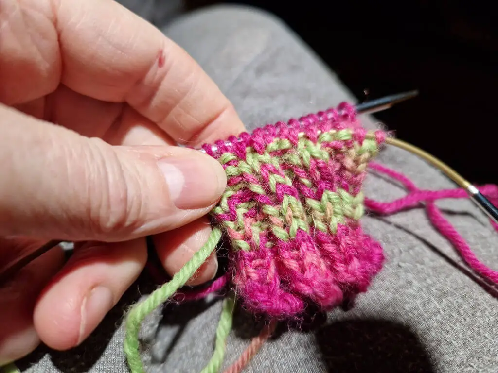 A small sock cast-on with yarn in pink and green stripes