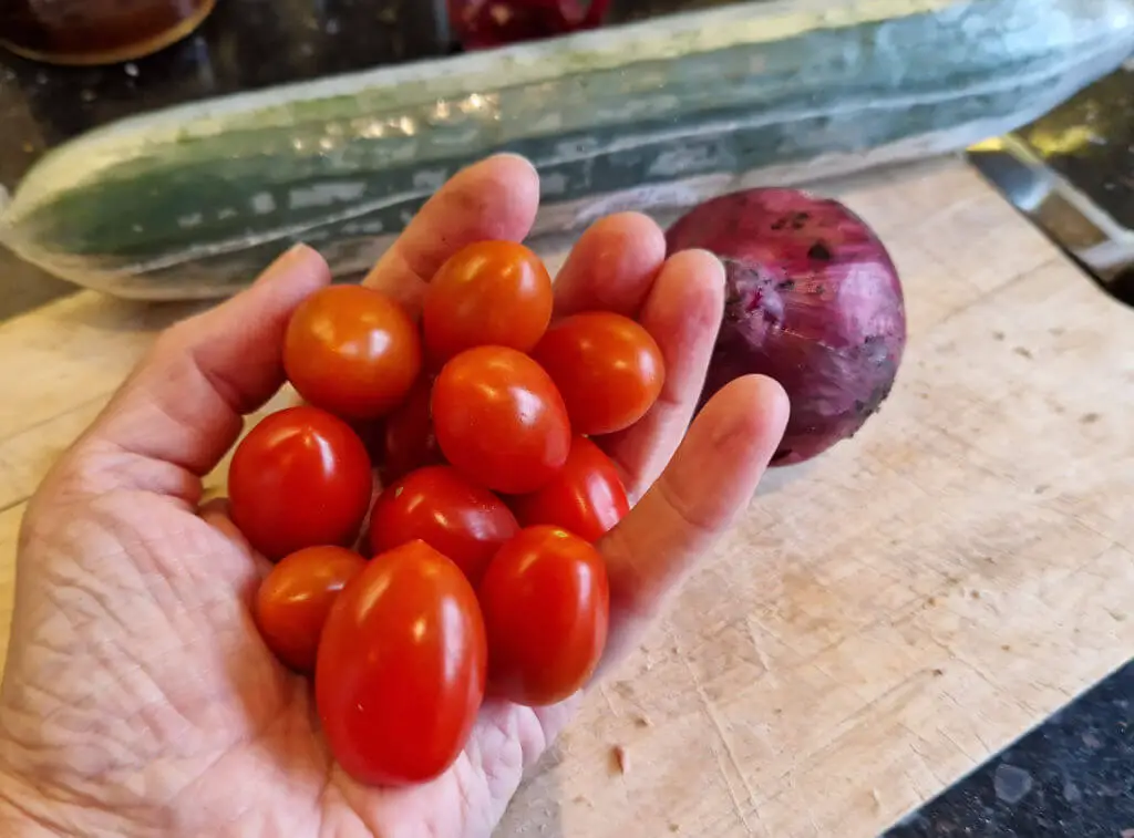 A handful of bright red miniature plum tomatoes