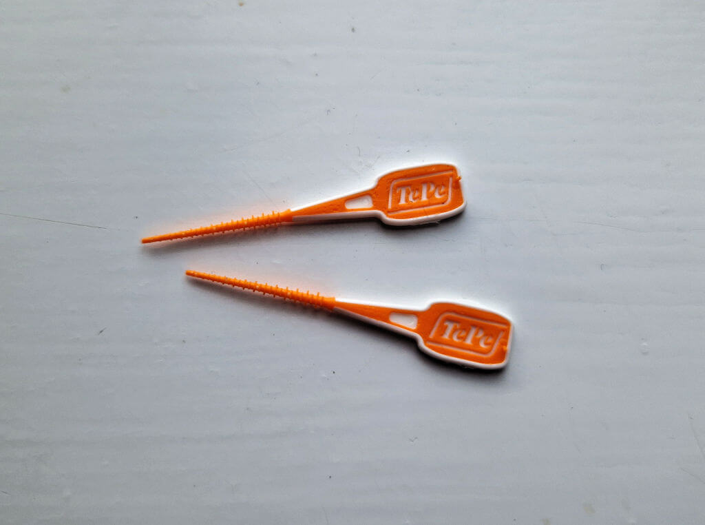 Two tiny orange inter-dental brushes