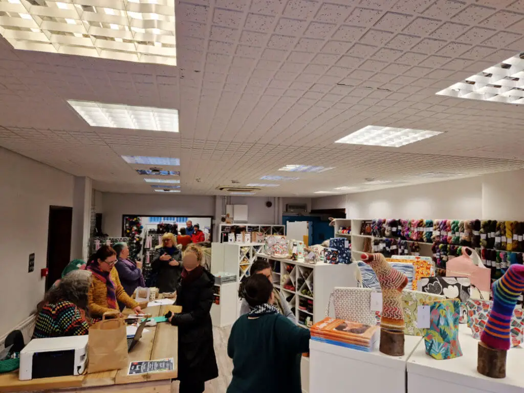 A view across a shop filled with display stands of yarn