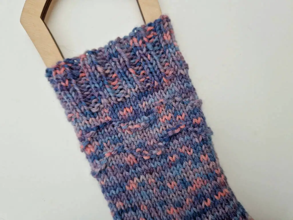 A close up of the textured pattern around the top of a sock leg