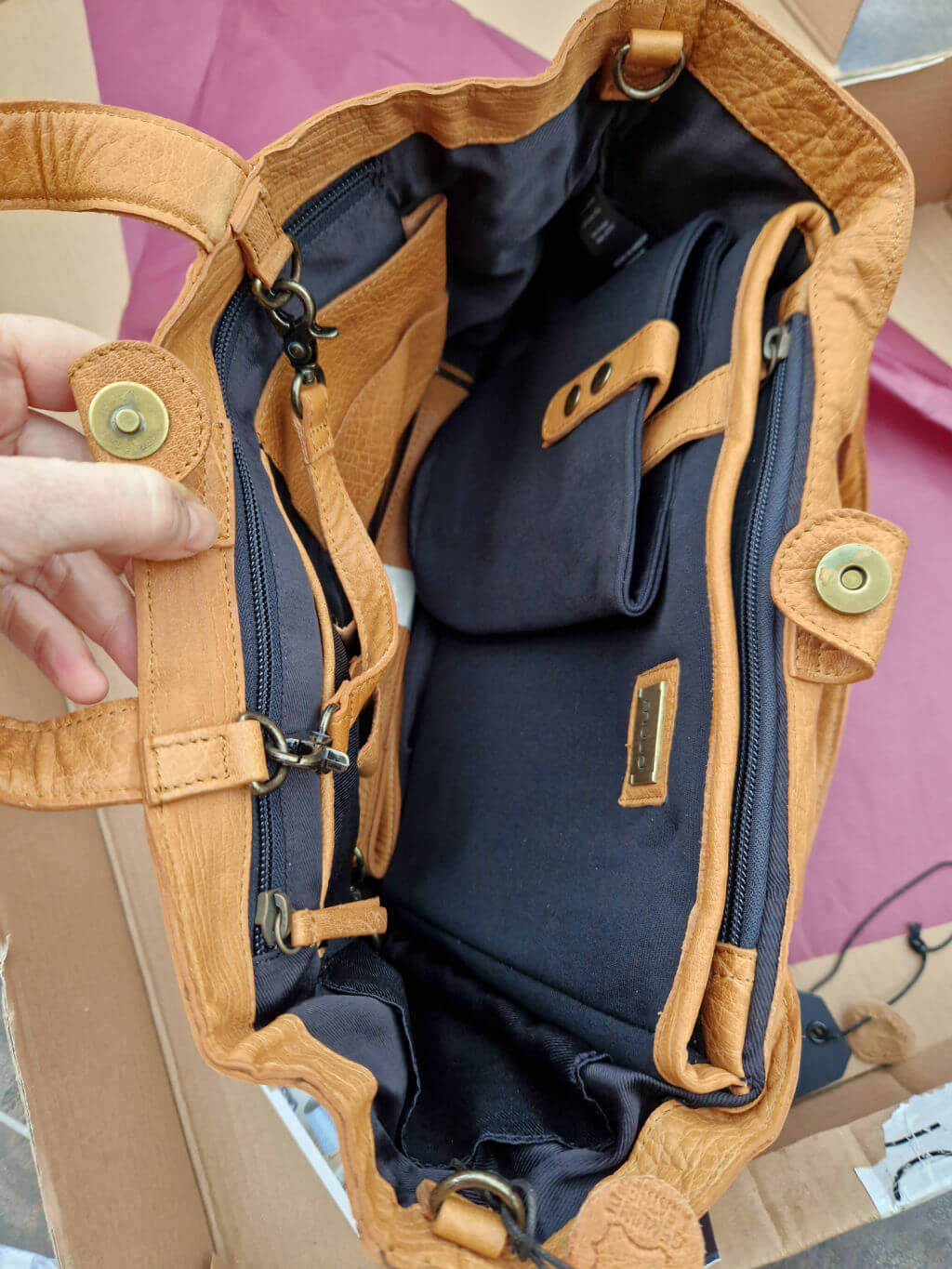 The inside pockets of a brown leather Muud Hiba bag