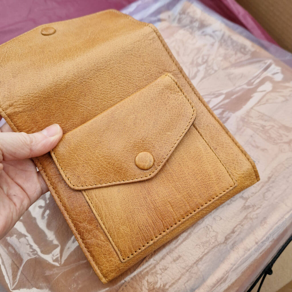 A close up of the back of a square brown Muud Civ leather case 