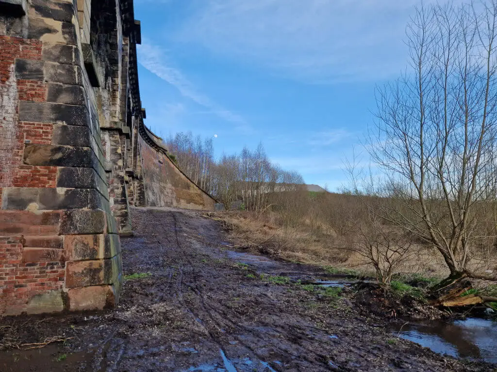 An area next to a stone railway viaduct cleared of vegetation