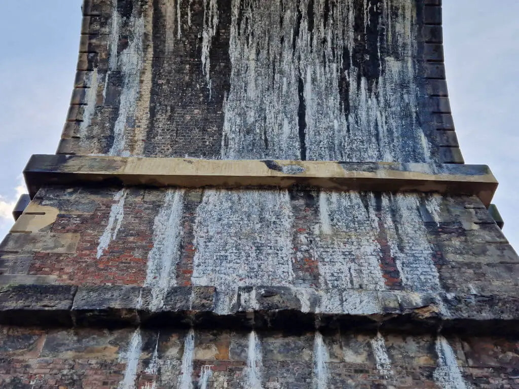 A repaired stone lintel previously damaged by lime dripping from the arched roof of a railway viaduct