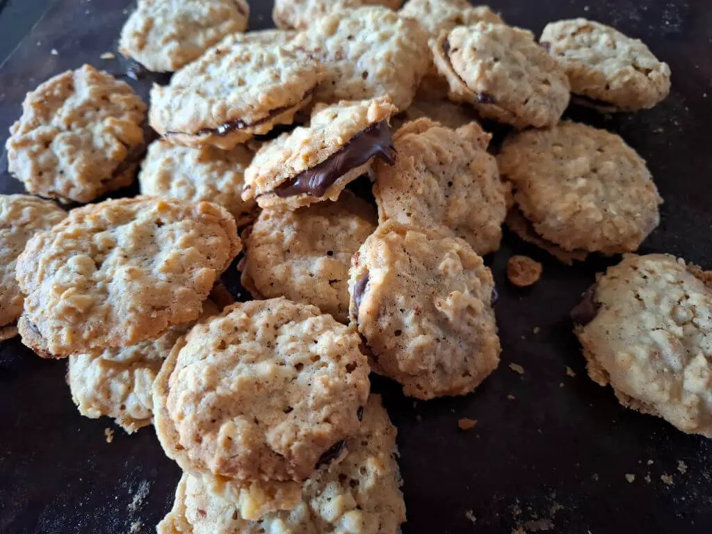 A tray of oatmeal biscuits (cookies) sandwiched together with chocolate