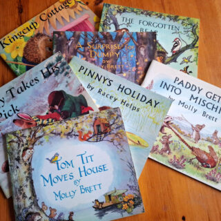 A selection of children's story books lying on a wooden table