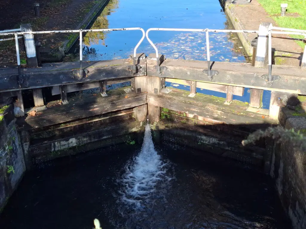 A close up of canal lock gates with water flowing through