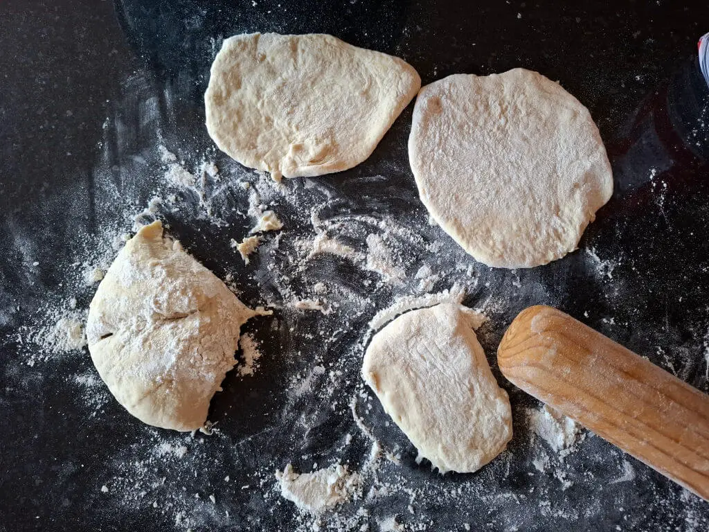 Flatbread shapes rolled out on a floured surface