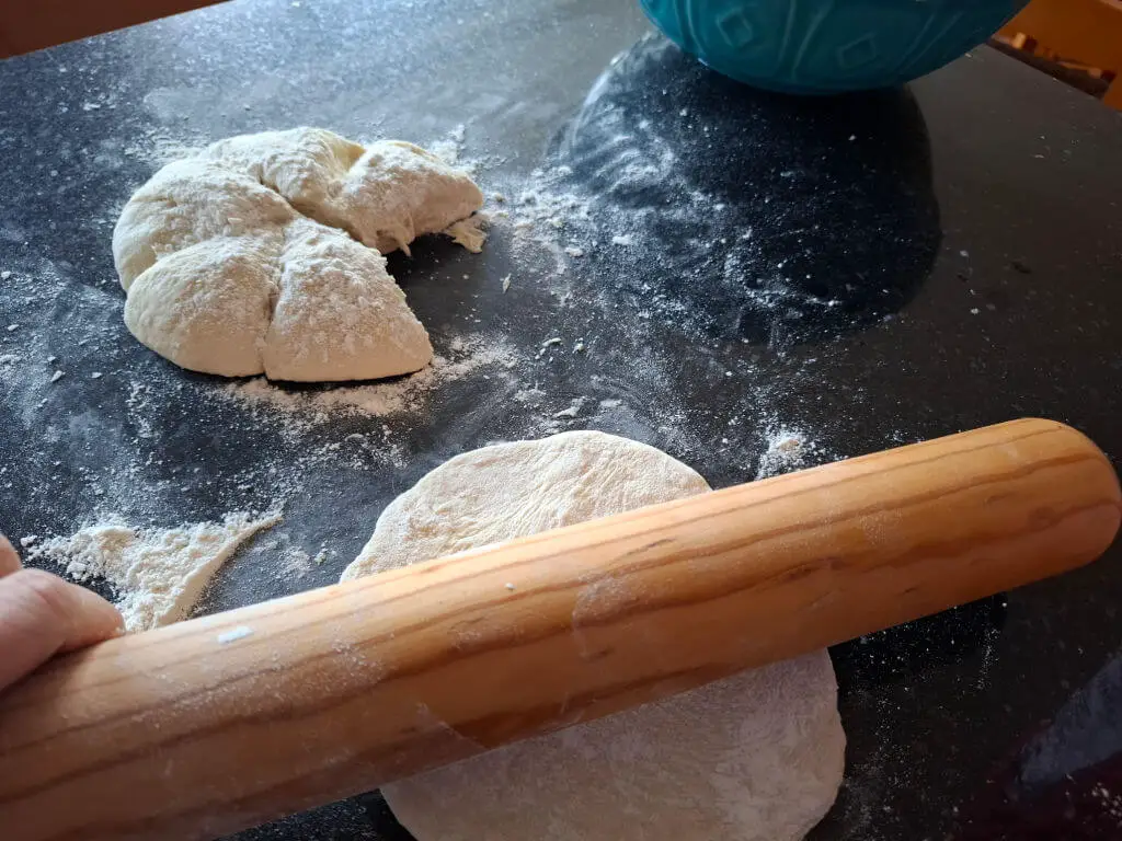 Rolling out flatbreads with a wooden rolling pin